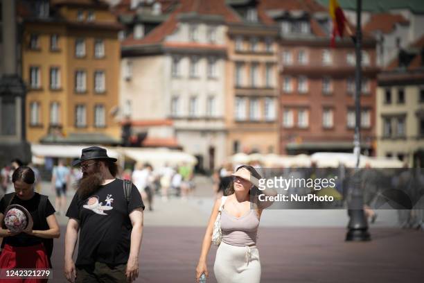 Woman is seen covering her eyes with her hand against the bright sun in the Old Town in Warsaw, Poland on 5 August, 2022. Warnings have been given...