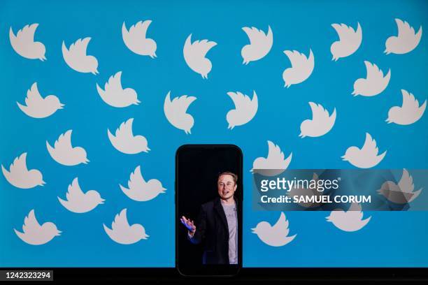 This illustration photo taken on August 5, 2022 shows a cellphone displaying a photo of Elon Musk placed on a computer monitor filled with Twitter...