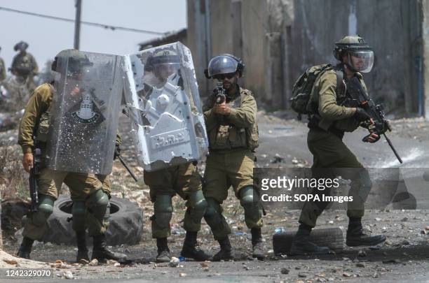 Israeli soldiers fire rubber bullets at the Palestinian protesters, during the demonstration against Israeli settlements in the village of Kafr...