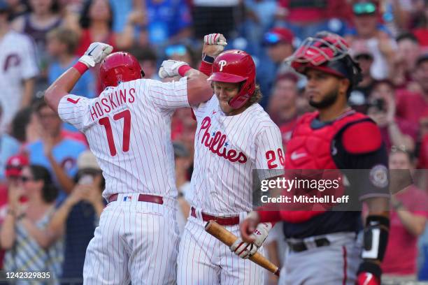 Rhys Hoskins of the Philadelphia Phillies celebrates with Alec Bohm after hitting a solo home run as Keibert Ruiz of the Washington Nationals looks...