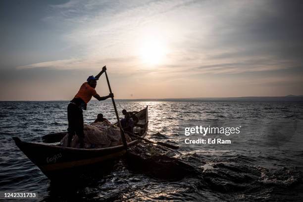 Men row out to fish using a large net on Lake Victoria on August 5, 2022 in Kisumu, Kenya. The fishing industry, which has been negatively impacted...