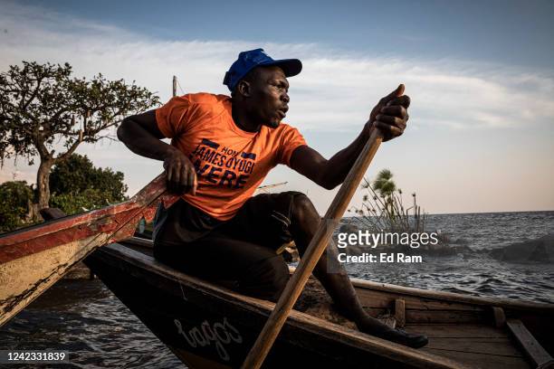 Fishing boats arrive at a dock on the edge of Lake Victoria at dawn as people gather to buy the nights catch, on August 5, 2022 in Kisumu, Kenya. The...