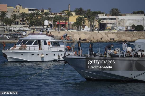 Tourists seen beyond a patrol boat with migrants in Lampedusa, Italy on August 04, 2022. Three landing operations of migrants, nearly 100 people of...