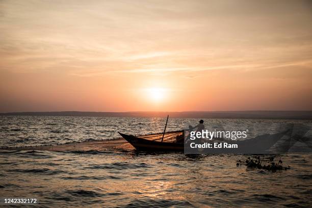 Men fish using a large net on Lake Victoria on August 5, 2022 in Kisumu, Kenya. The fishing industry, which has been negatively impacted by climate...