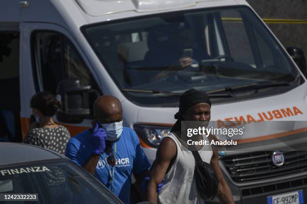 An officer of the UNHCR seen with a migrant in Lampedusa, Italy on August 04, 2022. Three landing operations of migrants, nearly 100 people of...