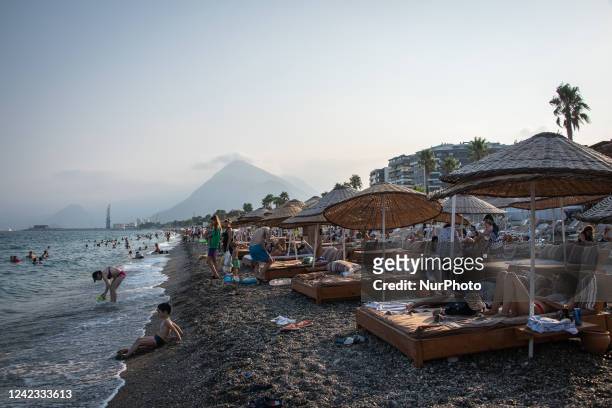 Turkish and international tourists visited the Antalya coast to sun bathe, relax under beach umbrellas and swim in the Mediterranean Sea in the...