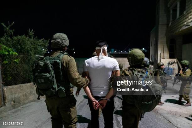 Israeli army members arrest a Palestinian during a raid in West Bank on August 6, 2022. Israeli army raid several cities, arresting some Palestinians...