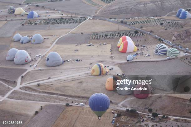 Hot air balloons glide over the sky at sunrise in Nevsehir, Turkiye on August 06, 2022. Hot air balloon tours providing a bird's eye view of the...