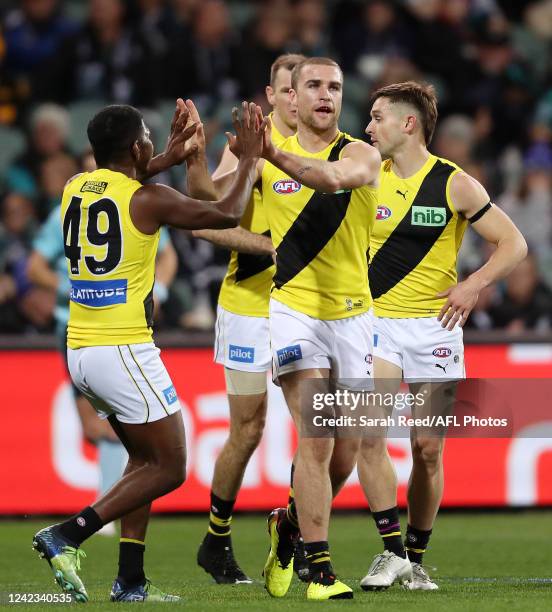 Jack Ross of the Tigers celebrates a goal with tam mates during the 2022 AFL Round 21 match between the Port Adelaide Power and the Richmond Tigers...