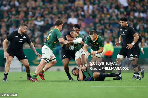 South Africa's fullback Damian Willemse is tackled by New Zealand's wing Caleb Clarke and New Zealand's hooker Samisoni Taukei'aho during the Rugby...