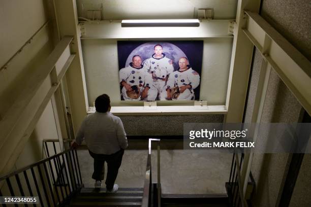 Person walks past an image of US astronauts at the Johnson Space Centers Mission Control Center in Houston, Texas, on August 5, 2022. - Rick LaBrode...