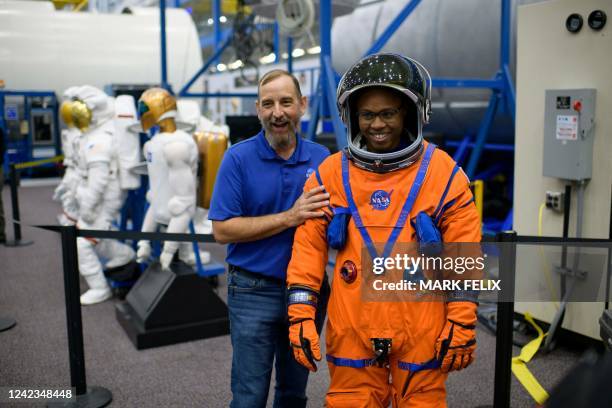 Suit technicians Bill Owens and Henry Phillips laugh while showing off a spacesuit at the Johnson Space Centers Space Vehicle Mock-up Facility in...