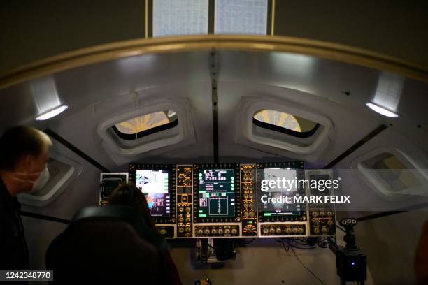 People look inside an Orion spacecraft simulator, which is used to train for docking to the Gateway space station, at the Johnson Space Centers...