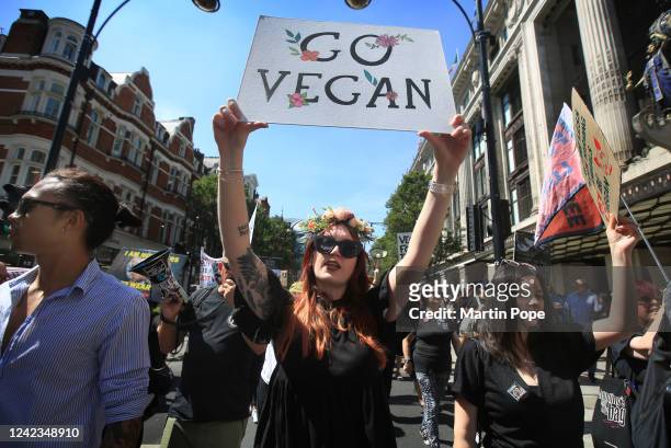 Protesters march across central London, one carries a sign saying 'Go Vegan' on August 6, 2022 in London, England. Protesters are marching for animal...