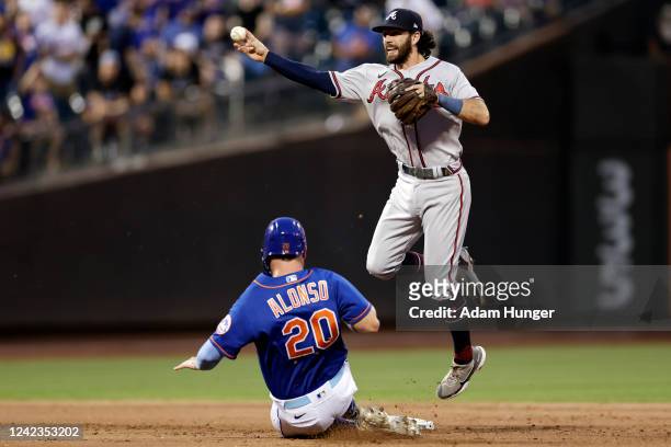 Dansby Swanson of the Atlanta Braves gets the force out on Pete Alonso of the New York Mets and then commits a throwing error during the third inning...