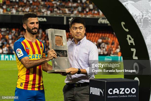 Jose Luis Gaya of Valencia CF and Valencia CF director Sean Bai poses for photos with the Taronja Trophy during the 50th Edition of Trofeu Toranja...