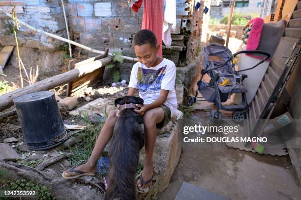 Eleven-year-old Miguel Barros, who received floods of food donations after calling police for being hungry, plays with his dog "Bigode" at his house...