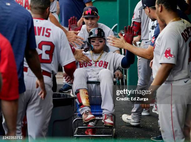 Alex Verdugo of the Boston Red Sox is pushed in a cart through the dug out by Jarren Duran after hitting a home run in the sixth inning against the...