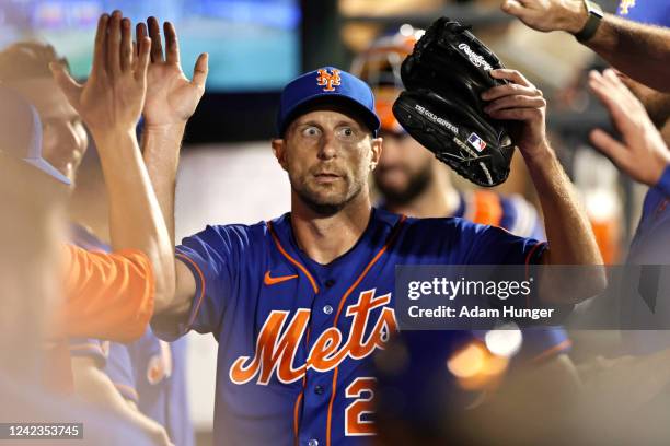 Max Scherzer of the New York Mets gets high-fives from teammates in the dugout during the seventh inning against the Atlanta Braves in the second...