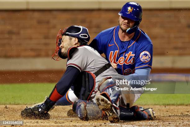Pete Alonso of the New York Mets scores a run as he collides with Travis d'Arnaud of the Atlanta Braves during the sixth inning in the second game of...