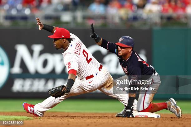 Ildemaro Vargas of the Washington Nationals is safe at second base as second baseman Jean Segura of the Philadelphia Phillies stretches for the ball...
