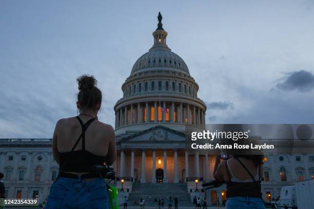 Tourists take photos of the U.S. Capitol building on the evening of August 6, 2022 in Washington, DC. The U.S. Senate plans to work through the night...
