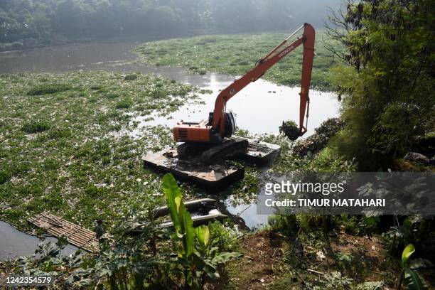 This picture taken on August 6, 2022 shows an excavator used to clean up a tributary of the polluted Citarum river in Bandung, West Java.
