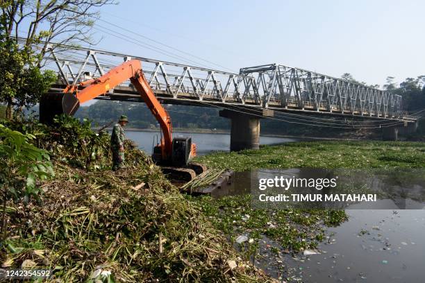 This picture taken on August 6, 2022 shows an excavator used to clean up a tributary of the polluted Citarum river in Bandung, West Java.