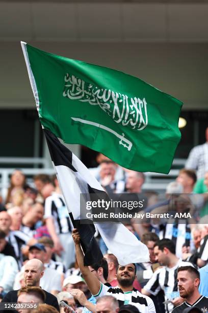 Fan of Newcastle United waves a flag of Saudi Arabia during the Premier League match between Newcastle United and Nottingham Forest at St. James Park...
