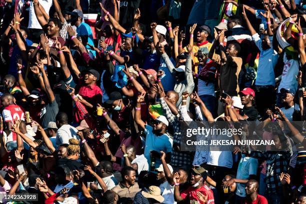 Zimbabwe supporters celebrates as a player hits a six during the second one-day international cricket match between Zimbabwe and Bangladesh at the...