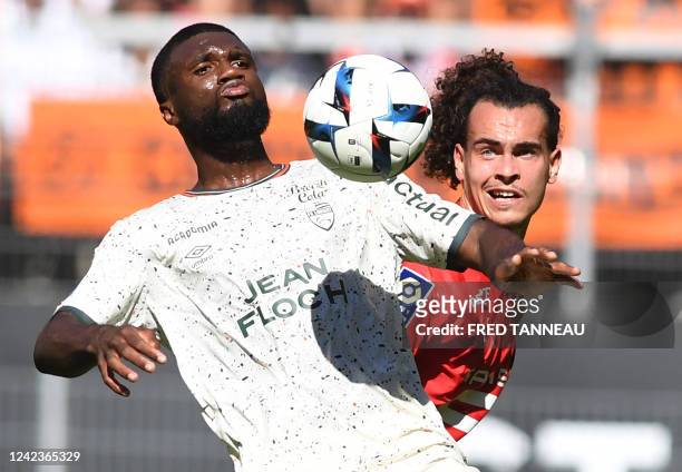 Rennes' Belgian defender Arthur Theate fights for the ball with Lorient's Nigerian forward Terem Moffi during the French L1 football match between...