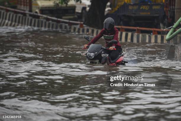 Vehicles wade through a heavily water logged street after sudden rains at Rohtak Road, on August 7, 2022 in New Delhi, India.