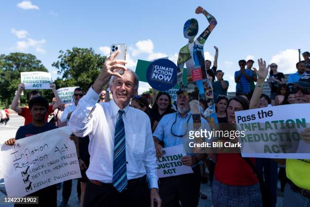 Sen. Ed Markey, D-Mass., shoots a selfie video with climate activists at the Senate steps after the Senate passed the Inflation Reduction Act in the...