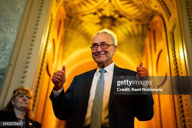 Senate Majority Leader Chuck Schumer gestures, walking out of the Senate Chamber, celebrating the passage of the Inflation Reduct Act at the U.S....