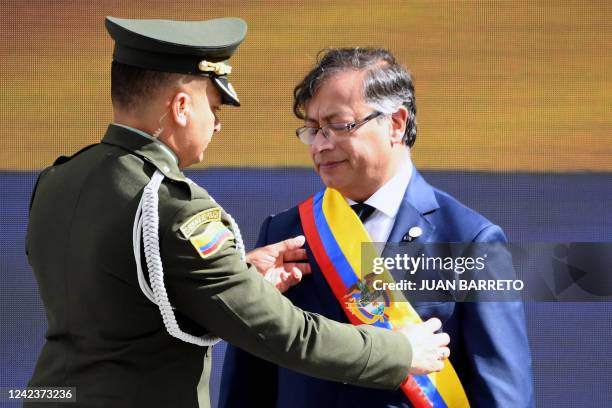 Colombia's Police Mayor Arley Farigua stregthens the presidential sash to Colombia's new President Gustavo Petro during the inauguration ceremony at...