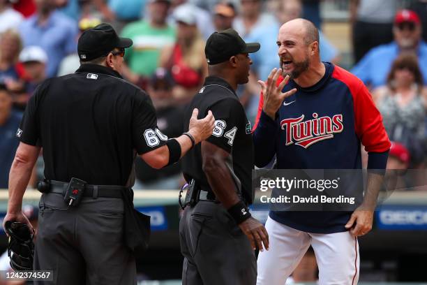 Rocco Baldelli of the Minnesota Twins argues with umpires Alan Porter and Marty Foster after a coach's challenge determined Whit Merrifield of the...