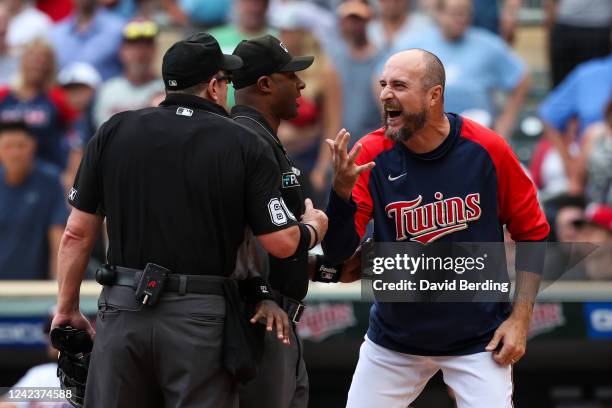 Rocco Baldelli of the Minnesota Twins argues with umpires Alan Porter and Marty Foster after a coach's challenge determined Whit Merrifield of the...