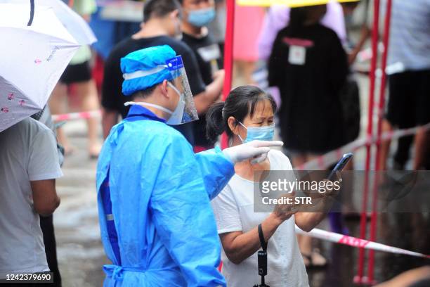 Medical worker speaks with a woman as residents and tourists queue to undergo nucleic acid tests for the Covid-19 coronavirus in Sanya in China's...