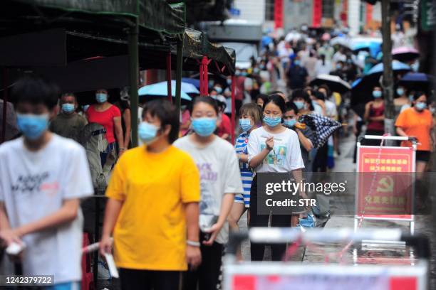 Residents and tourists queue to undergo nucleic acid tests for the Covid-19 coronavirus in Sanya in China's southern Hainan province on August 8,...