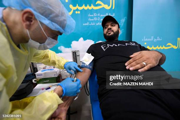 Bahraini Shiite Muslim takes part in a blood drive campaign to encourage donating blood instead of self-flagellation with swords to commemorate...