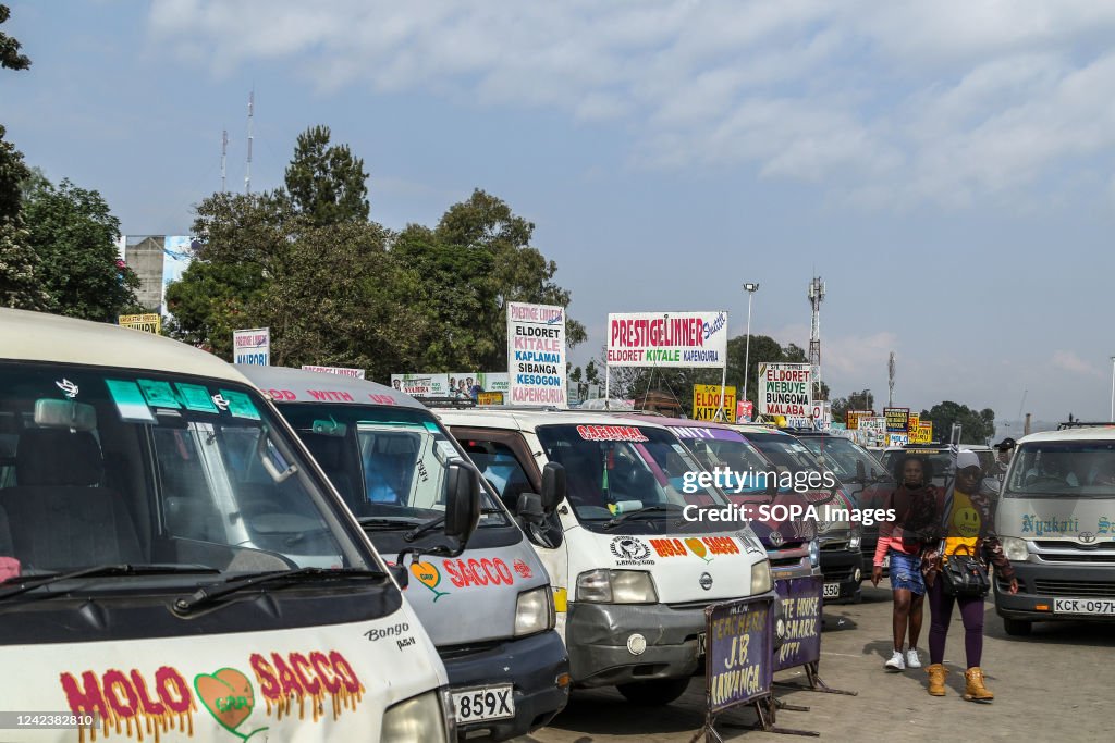 Travelers walk to board a minibus commonly known as a matatu...