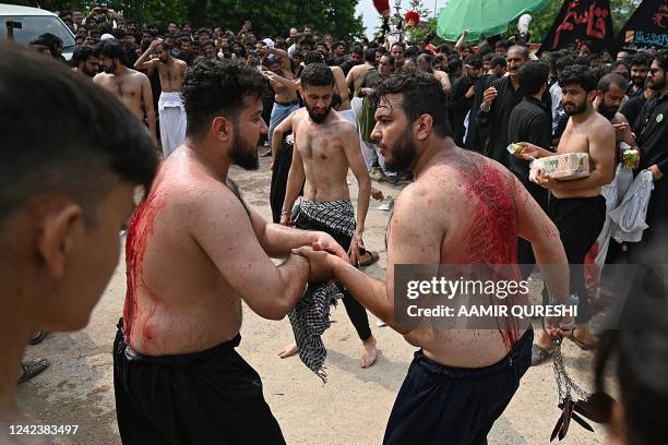 Shiite Muslim mourners self-flagellate during a Muharram procession on the ninth day of Ashura in Islamabad on August 8, 2022. - Ashura is a period...