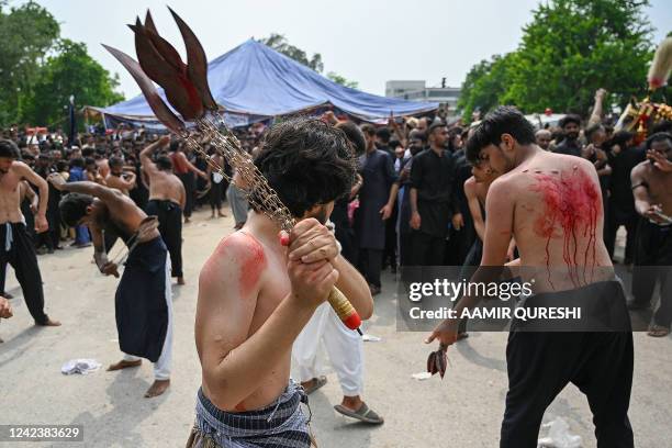 Shiite Muslim mourners self-flagellate during a Muharram procession on the ninth day of Ashura in Islamabad on August 8, 2022. - Ashura is a period...