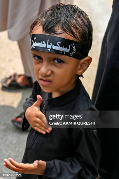 Shiite Muslim boy beats his chest during a Muharram procession on the ninth day of Ashura in Islamabad on August 8, 2022. Ashura is a period of...