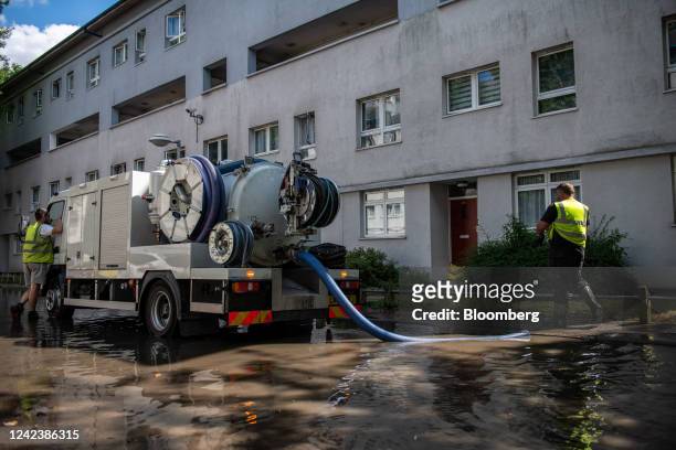 Workers attempt to pump out flood water on Hornsey Road caused by a burst water mains pipe in the Holloway district of London, UK, on Monday, Aug. 8,...