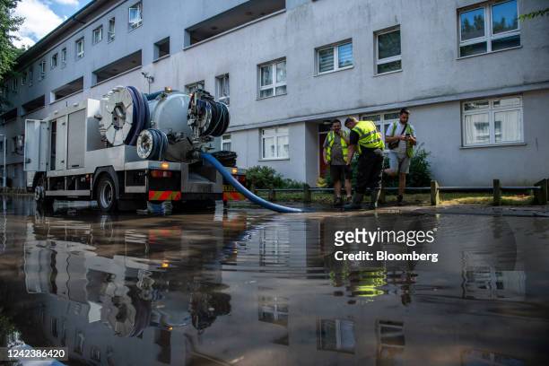 Workers attempt to pump out flood water on Hornsey Road caused by a burst water mains pipe in the Holloway district of London, UK, on Monday, Aug. 8,...