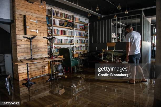 Local business owner inspects the damage caused by flood water on Hornsey Road caused by a burst water mains pipe in the Holloway district of London,...