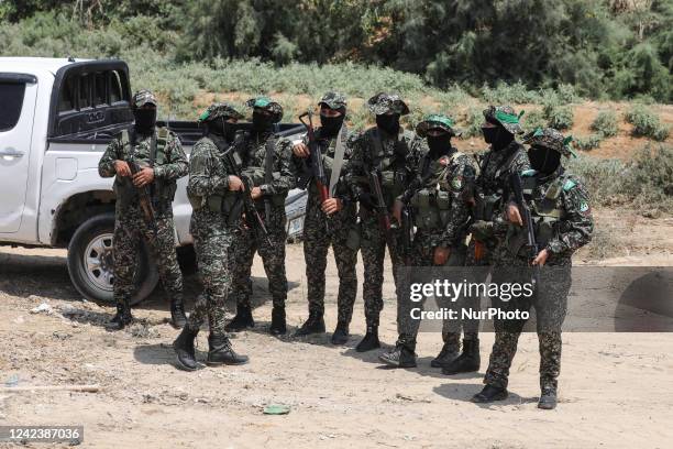 Masked members of the al-Qassam Brigades, the military wing of Hamas, march during the funeral of members of the al-Nabahin family during their...