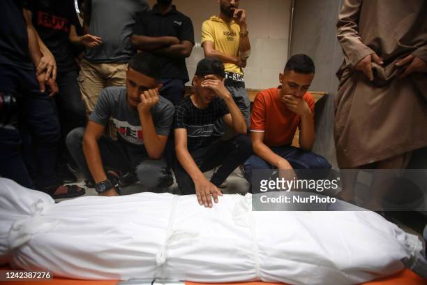 Mourners carry the body of Palestinian boy Najmeddin Najm, during his funeral in Jabalia in the northern Gaza Strip on August 8 after he was killed...