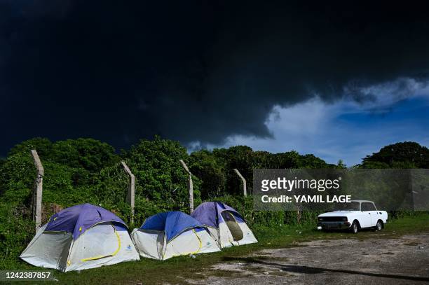 Firefighters' tents are displayed near a massive fire at a fuel depot sparked by a lightning strike in Matanzas, Cuba, on August 8, 2022. - Cuban...